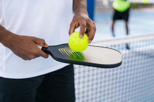 A Man is Holding a pickleball Paddle in KL - Arronax